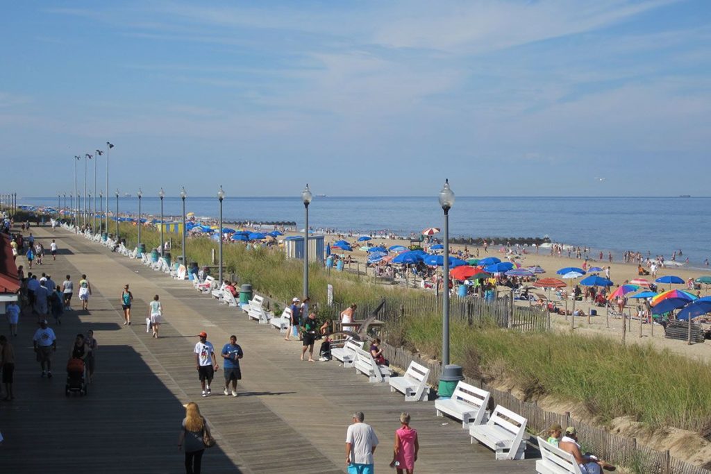 People walking on the boardwalk in the summer.